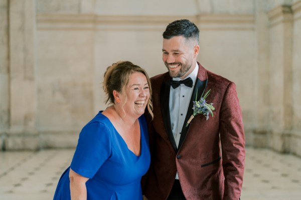 Mother in blue dress and groom smiling