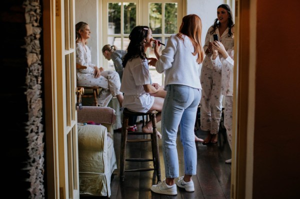 Bride getting her makeup done MUA and bridesmaid