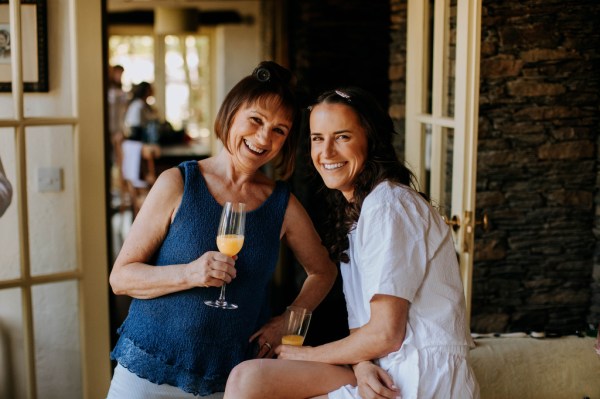 Bride and mother pose for a picture smiling