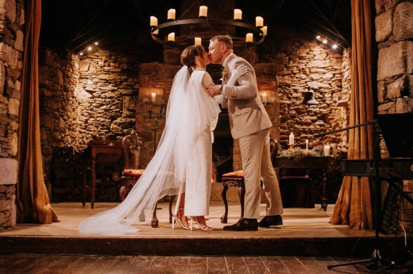 Bride and groom kiss at alter