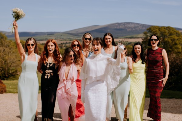 Bride walks in front of female friends and guests smiling