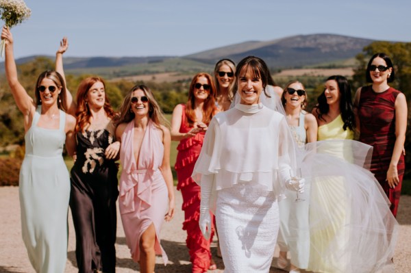 Bride walks in front of female friends and guests