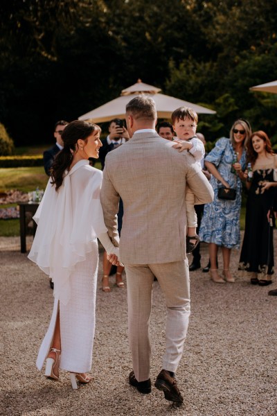 Bride and groom from behind walking towards guests