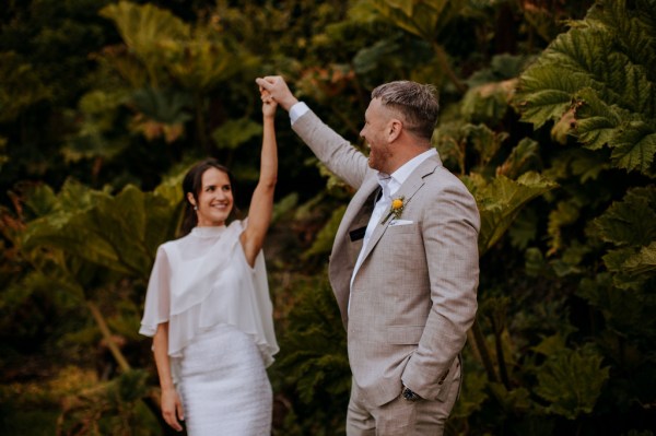 Bride and groom arms in the air smiling