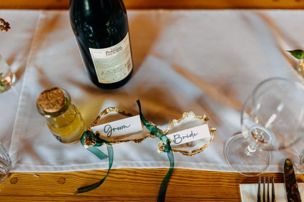 Placenames in white dishes beside a bottle of bubbly