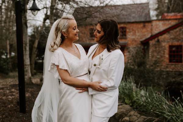 Brides look at each other barn setting