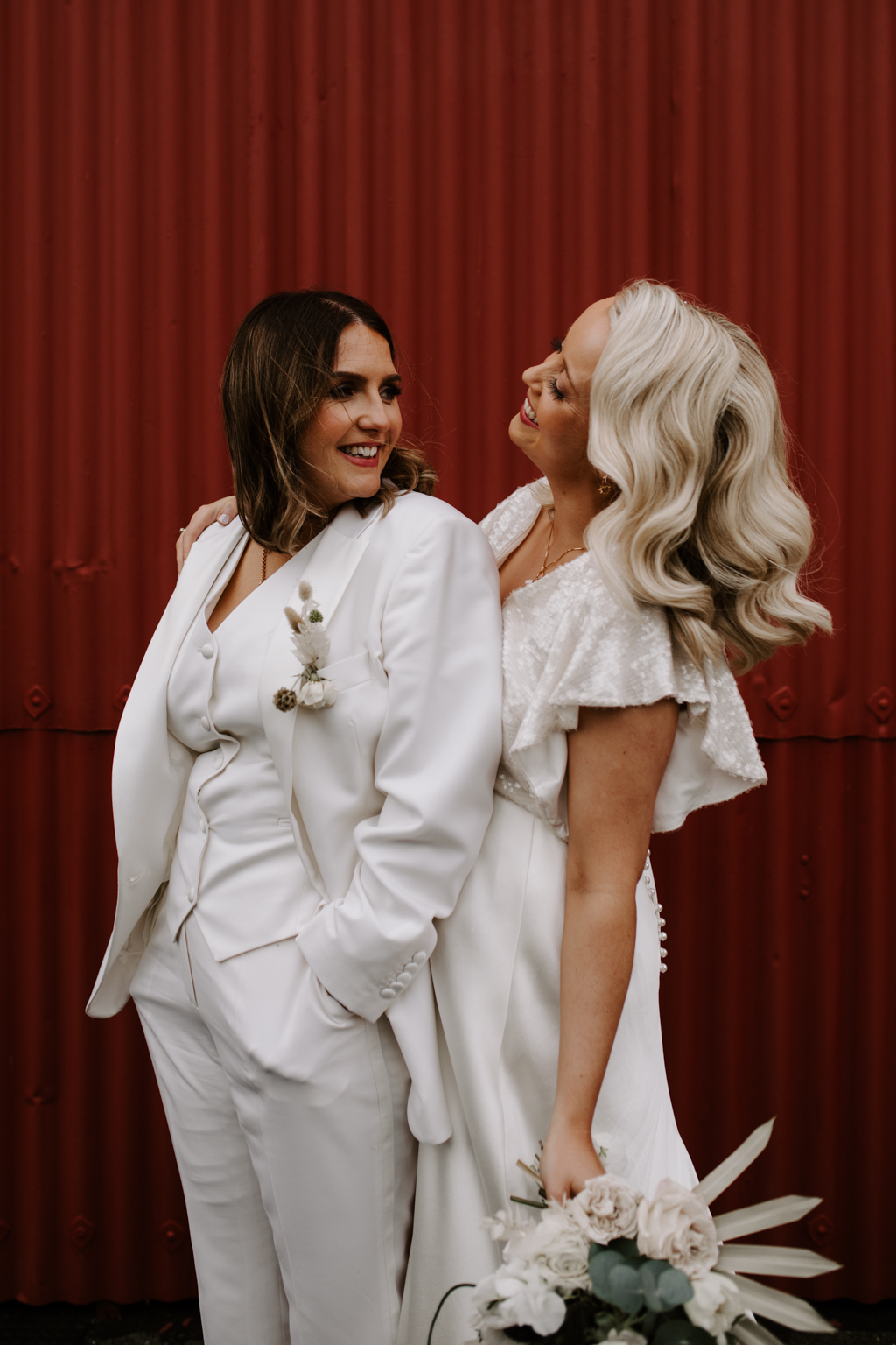 Brides against red backdrop door