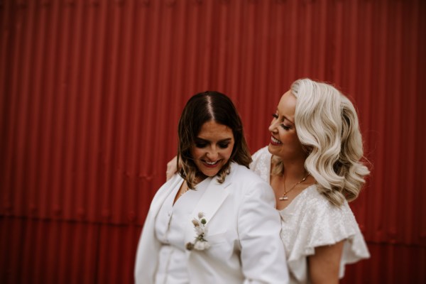 Brides against red backdrop door