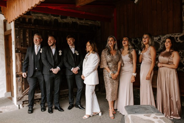 Bride in middle surrounded by bridesmaids and groomsmen