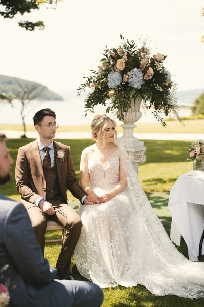 Bride and groom at top of alter during ceremony seated