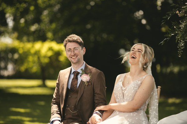 Bride and groom sit at the alter laughing away