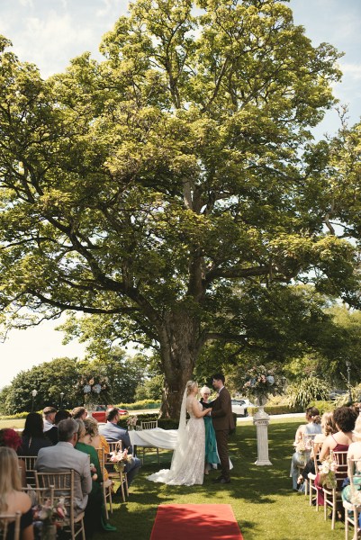 Bride and groom at top of alter during ceremony standing in front of guests