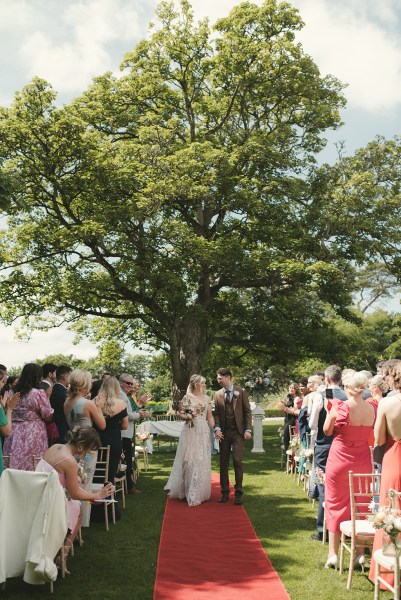 Bride and groom exit ceremony in front of guests