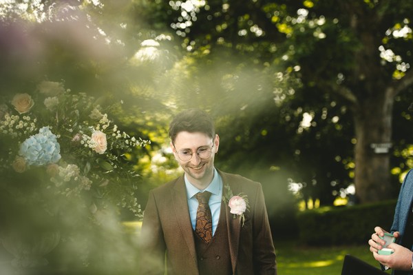 Groom smiles as he awaits his bride