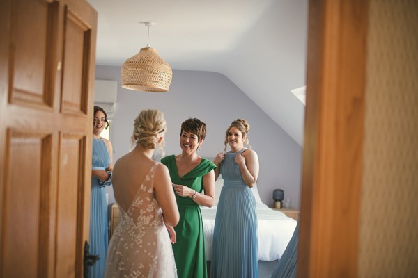 Bride from behind mother and bridesmaids are emotional