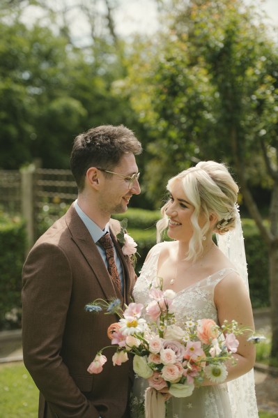 Bride and groom smile and look at each other