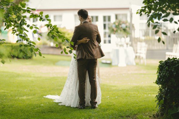 Bride and groom dance hug on the grass