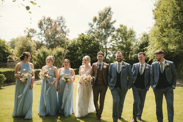 Bride in the middle bridesmaids and groomsmen on either side