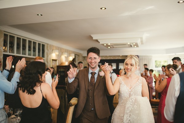 Bride and groom enter the ballroom holding hands