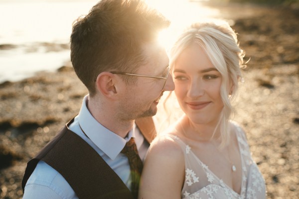 Bride and groom in beach setting sunset behind couple