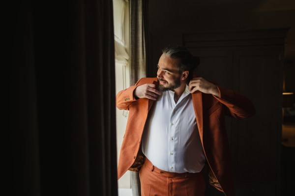 Groom in orange suit getting ready