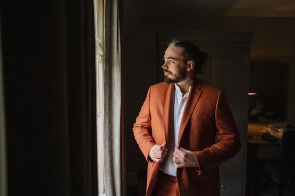 Groom in orange suit getting ready