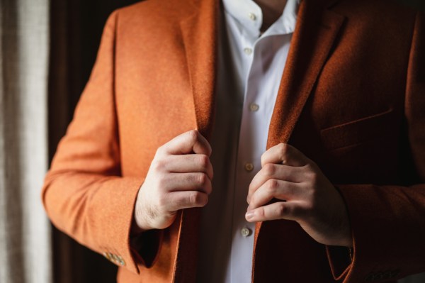 Groom in orange suit getting ready