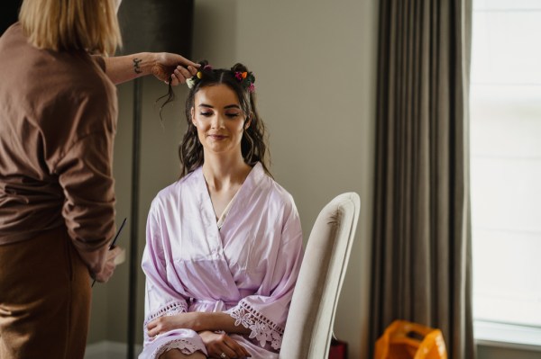 Woman gets ready hair sitting in purple silky robe