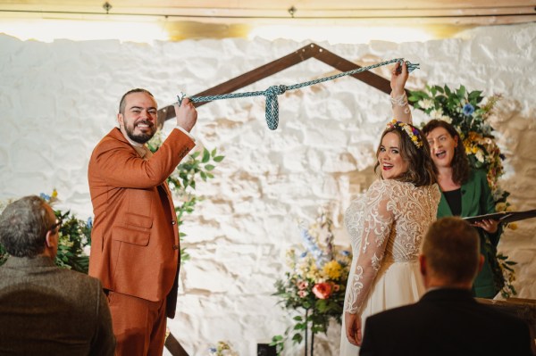 Bride and groom hold up blue ribbon