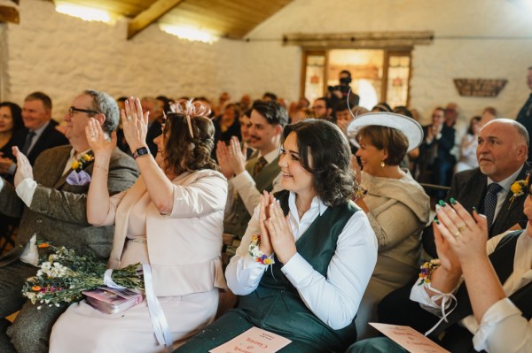 Guests in audience clap for the happy couple