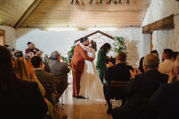 Bride and groom are pronounced husband and wife at alter they kiss