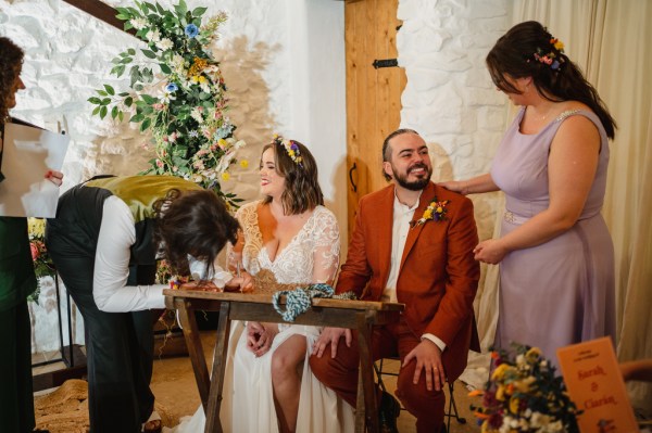 Bride and groom sign marriage certificate with witnesses