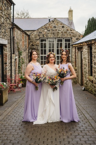 Bride and bridesmaids pose in courtyard to hotel