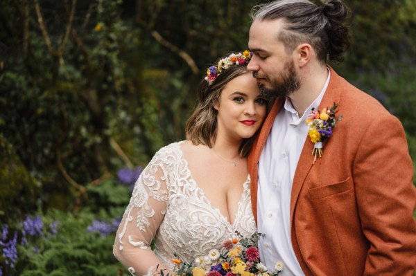 Bride and groom embrace in forest setting