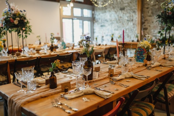 Daisies flowers and cutlery on the wooden ballroom table wide shot