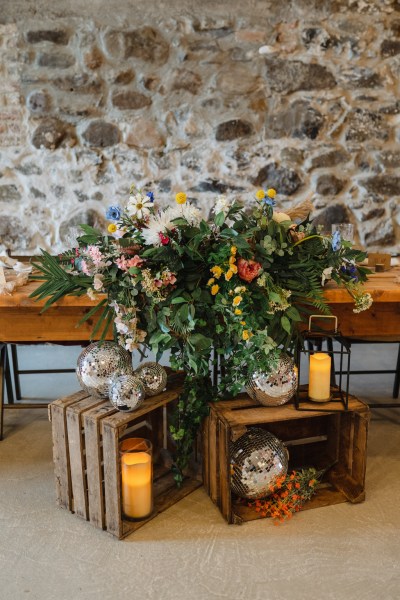 Flowers sitting resting on table while candles are lit