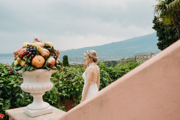 bride walks down the staircase to wedding venue scenic landscape in background