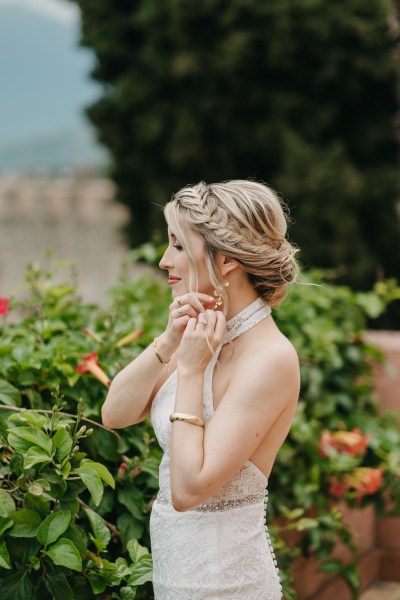 blonde bride puts on her earrings