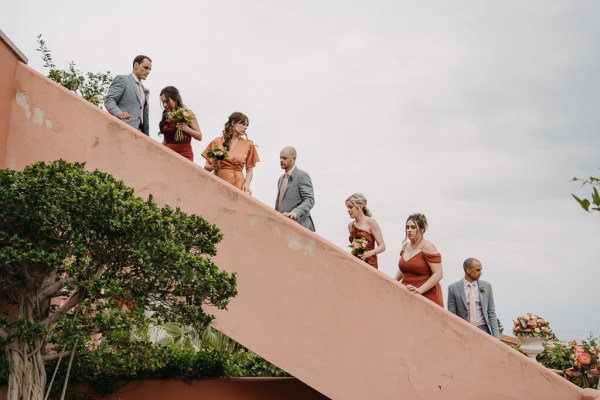 group photo bride bridesmaids groom and groomsmen walk up the wedding venue steps