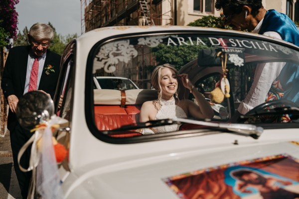 bride gestures from wedding car window