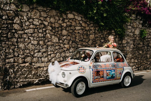 bride pops her head out of roof of wedding car