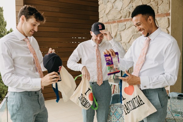 groom and groomsmen open gifts presents