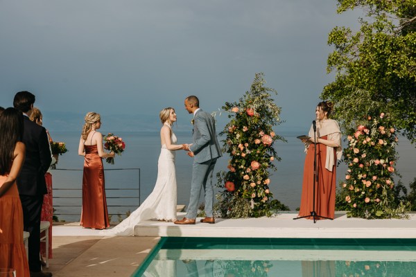 bride groom celebrant in front of swimming pool groomsmen and bridesmaids at either side