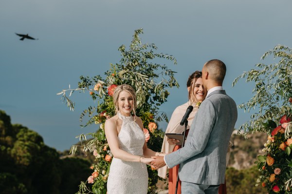 bride groom celebrant all smiling at top of ceremony alter