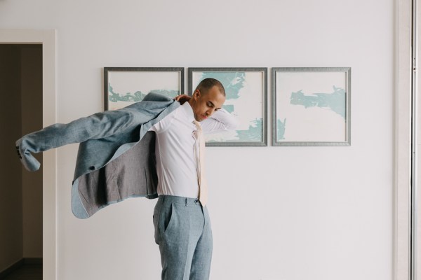 groom puts on his suit jacket and gets ready