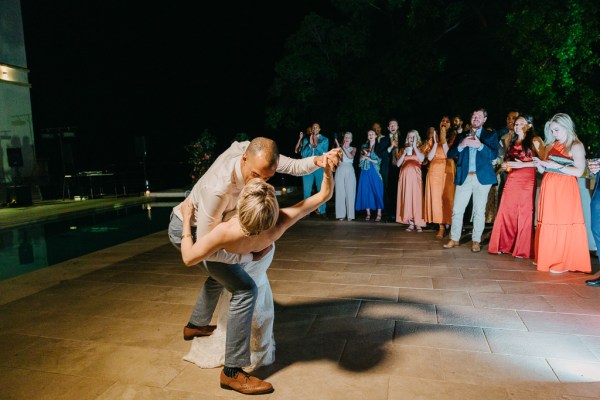 bride and groom dance surrounded by guests