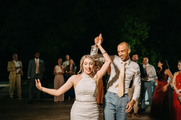 bride and groom dance surrounded by guests