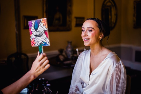 Bride getting her makeup done MUA lipstick mirror reflection