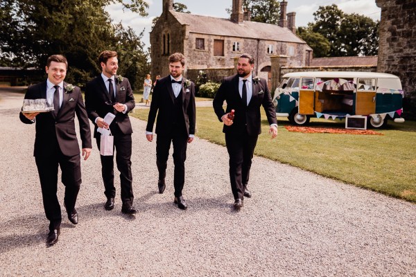 Groom and groomsmen walk the courtyard pathway