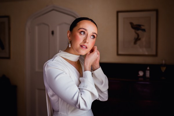 Bride puts on her earrings getting ready